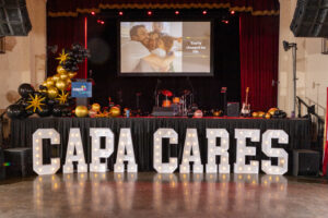 CAPACARES spelled in marquee letters in front of the stage