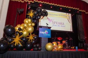 Podium with CAPACares and Speaks Chapels logos